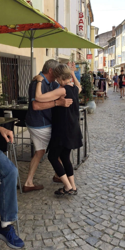 Liz and shop keeper dancing the tango in the street in Dieulefit, France